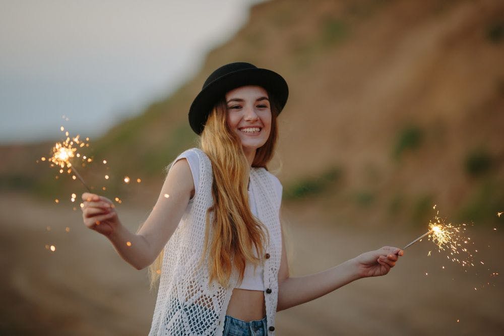 A young woman outside in the desert with sparklers