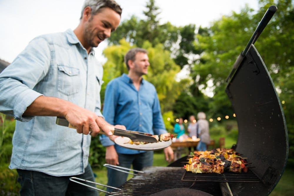 People at a backyard party enjoying grilled food