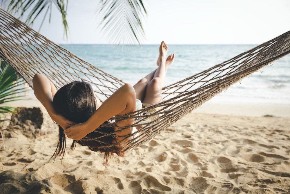 A woman in a hammock on the beach