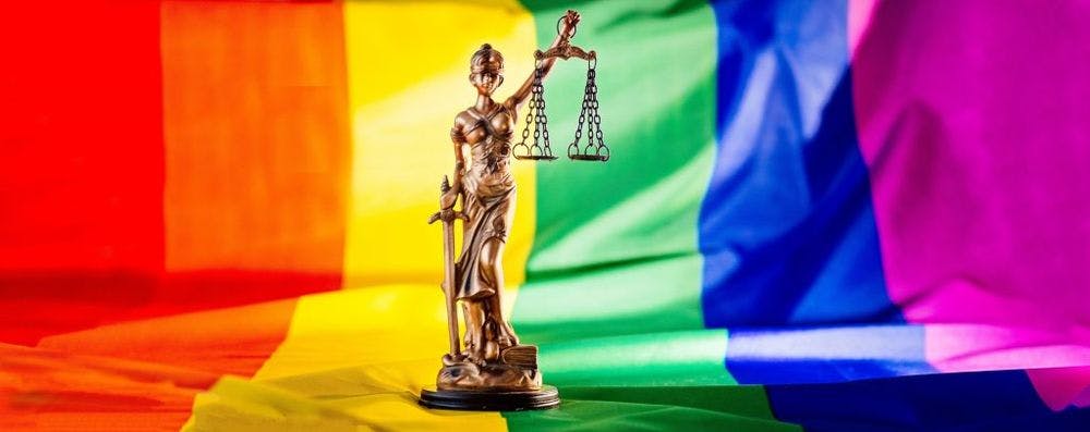 Statue of justice symbol of law and justice with lgbt flag in rainbow colours. Lgbt rights and law