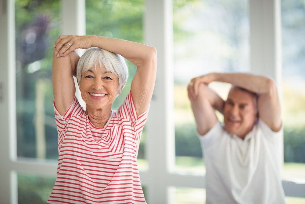 older woman and man stretching for exercise 