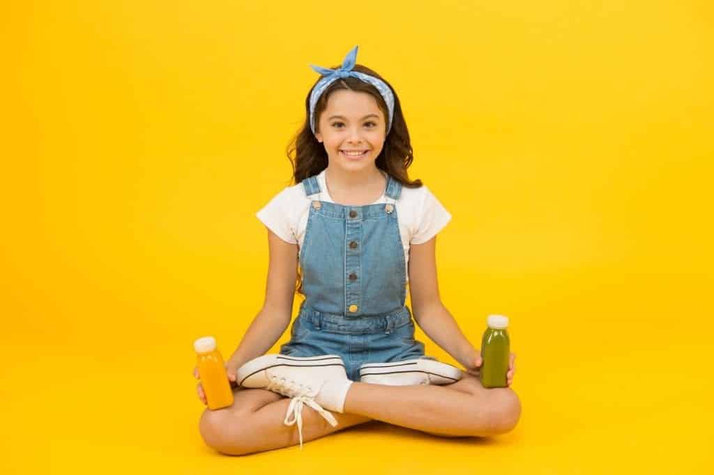 Yoga training. KId girl sit meditate. Meditating practice. Good vibes. Peaceful meditating. Vegetarian smoothie drink. Learn meditating techniques. Stay positive and optimistic. Healthy way of life.